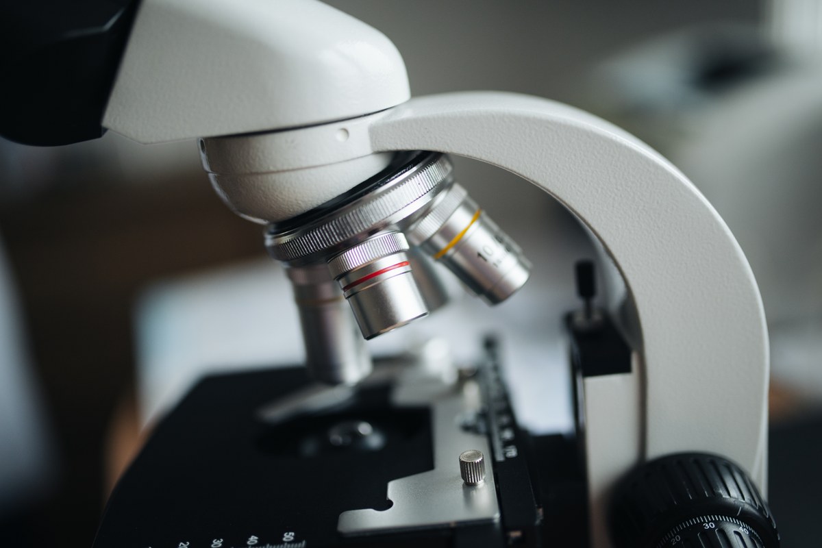 Close view of three objective lenses on a compound microscope above its stage