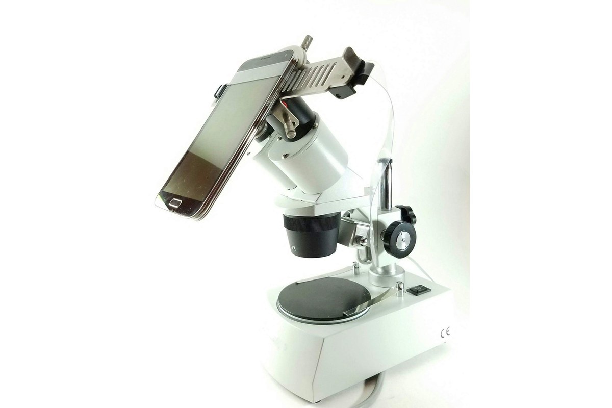 Smartphone secured in an adjustable adapter above a microscope eyepiece for taking pictures